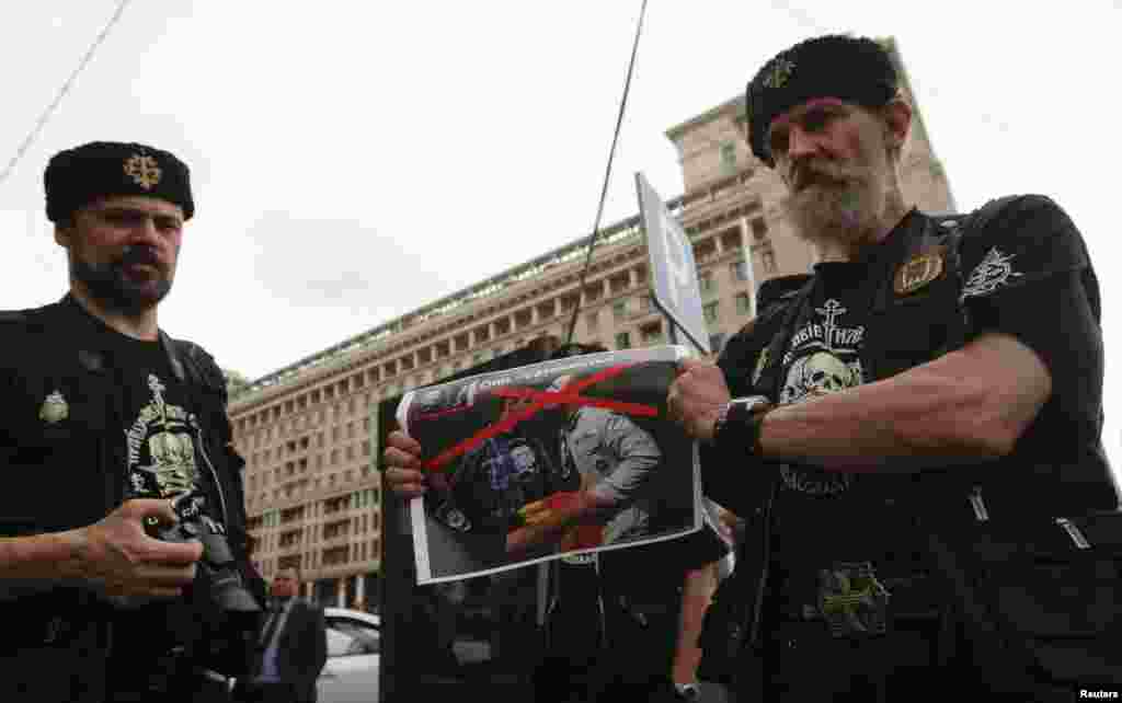 An Orthodox believer holds a poster before a protest by gay-rights activists.