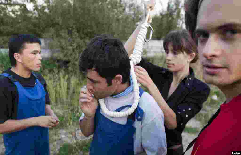 Activists Pyotr Verzilov (right) and his wife, Nadezhda Tolokonnikova, prepare a migrant worker for a mock execution at a Moscow megastore in September 2008.