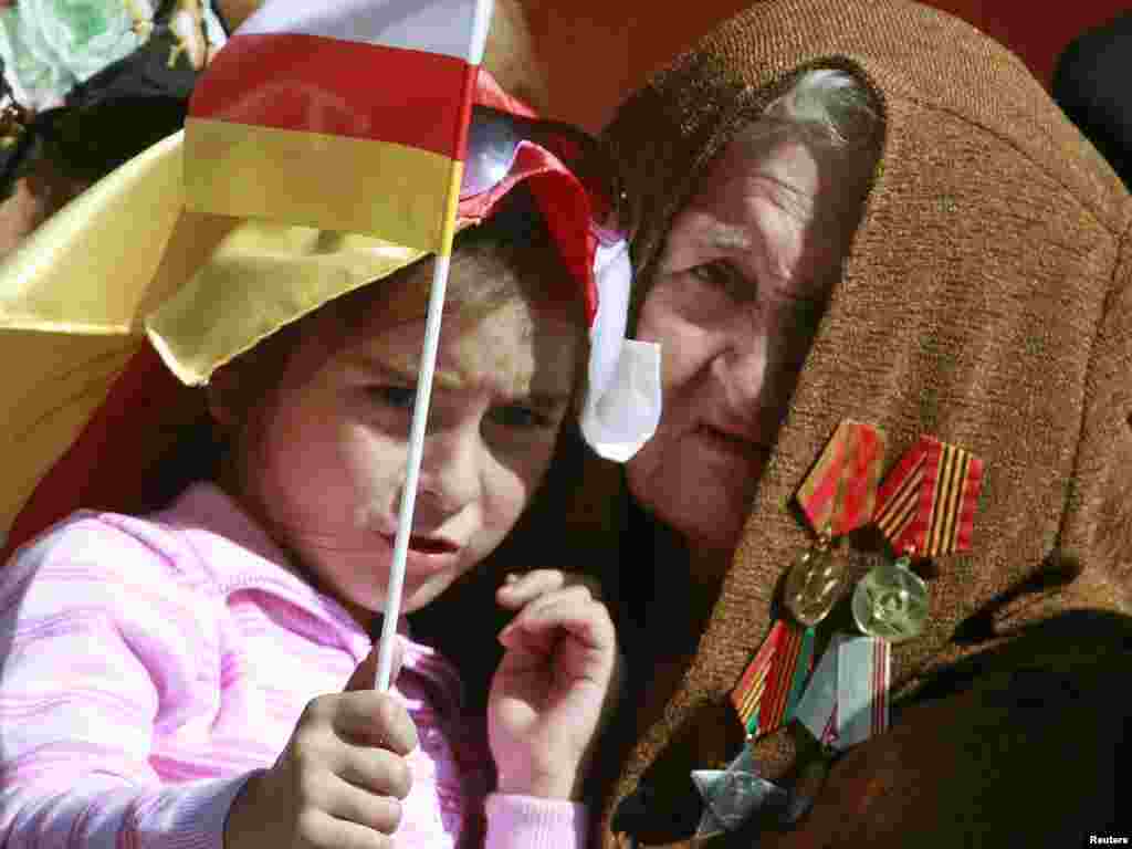 Georgia - A woman holds a girl with South Ossetian flag during the Independence Day celebration in South Ossetia's main city of Tskhinvali, 20Sep2010 - A woman holds a girl with South Ossetian flag during the Independence Day celebration in South Ossetia's main city of Tskhinvali, September 20, 2010. The Georgian break away region of South Ossetia celebrated on Monday the 20th anniversary of declaring itself independent from Georgia. REUTERS/Kazbeg Basayev (GEORGIA - Tags: POLITICS) potw38 10poty