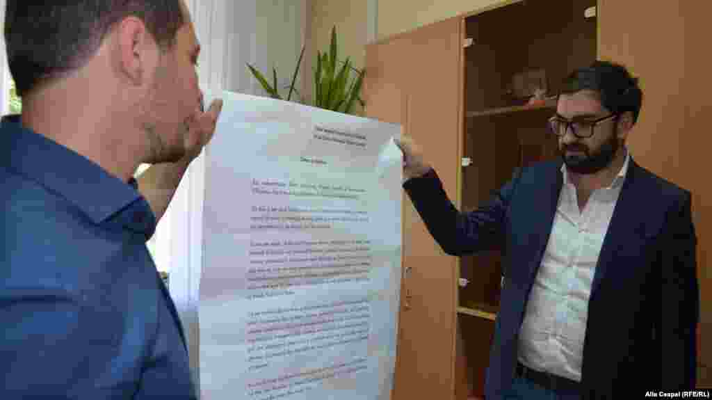 Consilierii municipali PPEM, Victor Lutenco și Ruslan Codreanu, prezentînd cererea de demisie a primarului.