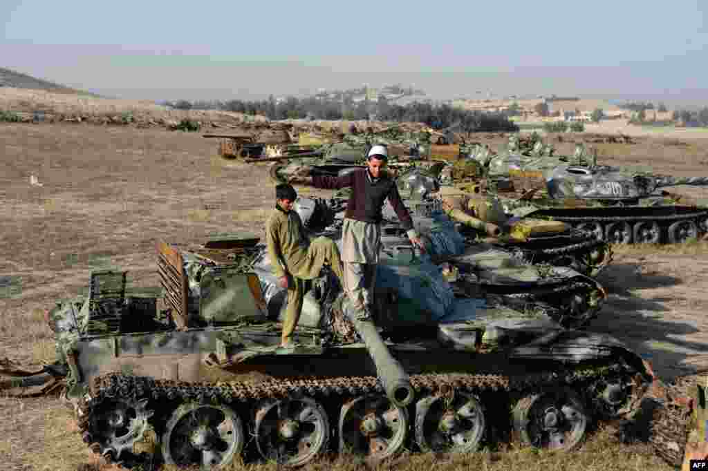Аўганскія дзеці гуляюццца на парэштках танка часоў савецкай акупацыі на ўскрайку гораду Джэлялябад. (Фота AFP)