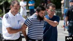 Kosovo police officers escort a man suspected of having fought with Islamist insurgents in Syria and Iraq as they arrive at a court in Pristina on August 12.