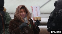  A Belarusian pensioner holds religious icons as she attends a pensioners' rally to protest the official presidential election results in Minsk on December 14. 