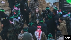 Militanții Hamas o escortează pe ostatica israeliană Agam Berger (centru) înainte de a o preda Crucii Roșii în Jabalia, Gaza. 30 ianuarie, 2025. 