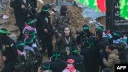  Членове на Хамас ескортират израелската заложничка Агам Бергер, преди да я предадат на екип на Червения кръст, 30 януари 2025 година 