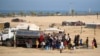 Raseljeni Palestinci stoje u redu da kupe vodu, pored svog privremenog kampa u Rafi, Pojas Gaze, 17. maj 2024.
