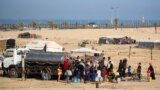 توزیع آب آشامیدنی بین آوارگان فلسطینی در اردوگاهی موقت در اطراف رفح