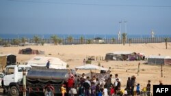 Раселени Палестинци чекаат ред за вода пред привремениот камп во Рафа на 17 мај 2024 година.
