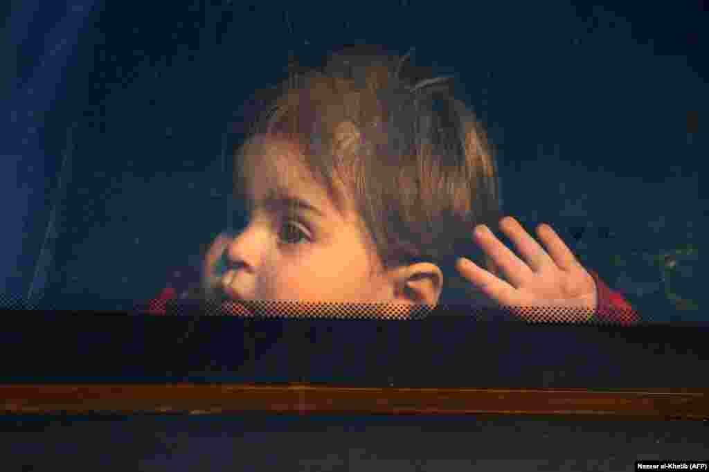 A child looks out of the window of a bus upon arrival at the Abu al-Zindeen checkpoint near the northern Syrian town of Al-Bab after Jaish al-Islam fighters and their families were evacuated from the last rebel-held pocket in eastern Ghouta on April 3. (AFP/Nazeer al-Khatib)