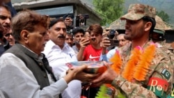 People present sweets to Pakistan Army soldiers as part of celebrations following the announcement of a cease-fire between India and Pakistan, in Chakothi village in Pakistan-administered Kashmir on May 11. 