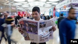 A man reading a newspaper in Tehran.