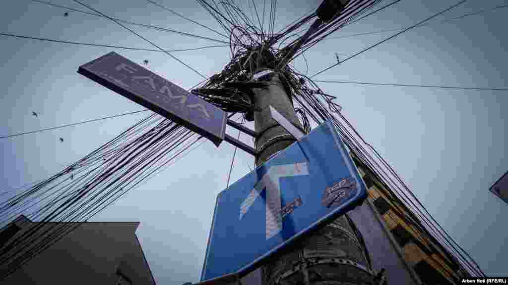 Një shyllë prej betoni si shpërndarëse e shumë kabllove te komunikimeve dhe rrymës në një rrugë të kryeqytetit.