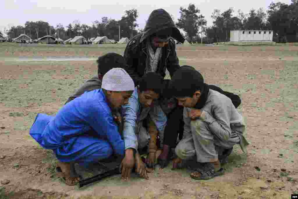 Afghan boys set the batting order before starting a game in Jalalabad.