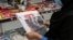 A woman browses the front page of the Iranian newspaper Sharq featuring the 2020 U.S. election results at a newsstand in Tehran on November 8, 2020.