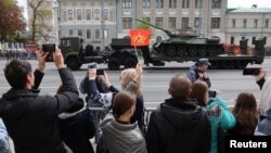 Spectatorii ruși privesc un camion care transportă un tanc T-34 din epoca sovietică, folosit la parada militară care marchează cea de-a 78-a aniversare a victoriei asupra Germaniei naziste în cel de-al Doilea Război Mondial, Moscova, Rusia, 9 mai 2023.