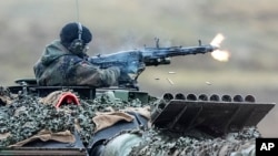 A soldier fires a machine gun from a Leopard 2 tank at a training ground in Augustdorf, Germany, in 2023. "If America doesn't come back on board" to support Ukraine, security expert Michael Clarke says, "then it really matters what Germany does."