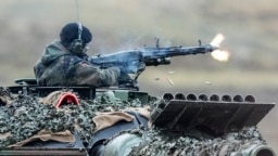 A soldier fires a machine gun from a Leopard 2 tank at a training ground in Augustdorf, Germany, in 2023. "If America doesn't come back on board" to support Ukraine, security expert Michael Clarke says, "then it really matters what Germany does."