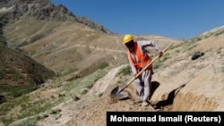 عکس ارشیف - یو افغان کارګر د اوبو رسولو لپاره غونډۍ کیندي. 