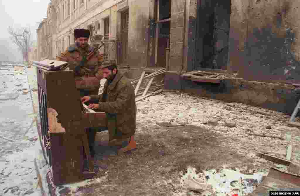 Чеченский боец играет на пианино в центре Грозного. Многие дома в первые дни войны были разграблены военнослужащими федеральных войск, а потом подвергнуты бомбардировке или подожжены. 22 декабря 1994 года.
