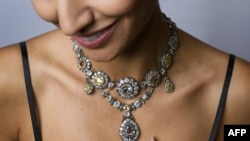 A model poses with a parure of antique colored diamond jewels during a press preview by Sotheby's auction house in Geneva, November 9, 2016