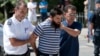 Kosovo police officers escort a man suspected of having fought with Islamist insurgents in Syria and Iraq as they arrive at a court in Pristina on August 12.