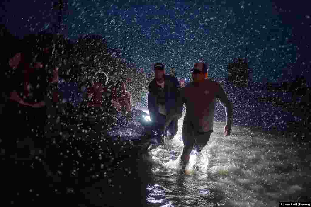 Volunteers&nbsp;help pull a boat with evacuees to high ground during Tropical Storm Harvey in East Houston, Texas, August 28, 2017. (Reuters/Adrees Latif)