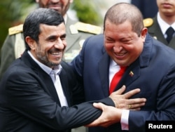 Iran's President Mahmud Ahmadinejad (L) is welcomed by Venezuela's President Hugo Chavez (R) at Miraflores Palace in Caracas, 09Jan2012