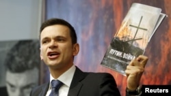 Russian opposition activist Ilya Yashin speaks to the media during a presentation of the report about the Russian military presence in Ukraine that murdered opposition leader Boris Nemtsov was working on shortly before his death, in Moscow on May 12.
