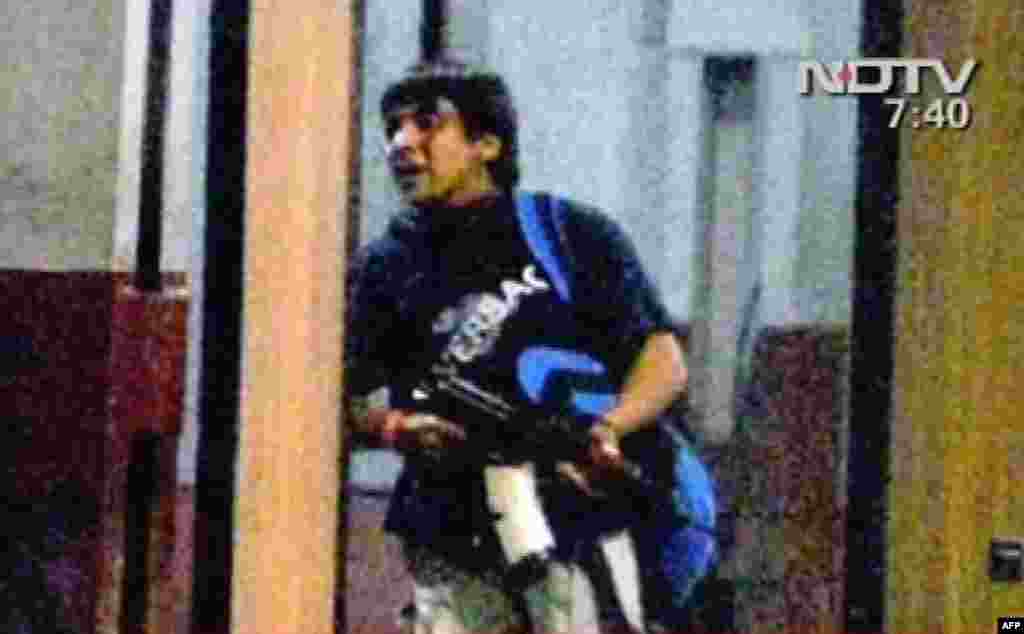 Kjo fotografi e marrë nga pamjet e NDTV-së tregon një njeri të armatosur duke hyrë në një stacion treni në Mumbai.