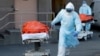 Медицинские работники везут каталку с телом умершего от осложнений, вызванных коронавирусом, Нью-Йорк, Бруклин, 4 апреля 2020 года