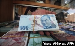 Egy köteg török líra egy kuvaiti pénzváltónál 2018-ban. A török valuta abban az évben is komoly értékvesztést szenvedett el, miután a NATO-szövetséges Egyesült Államok szankciókat vezetett be Törökország ellen