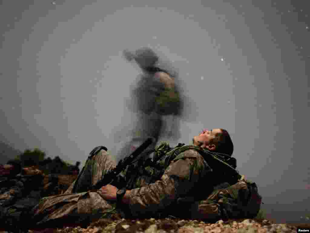 A U.S. soldier of 2-12 Infantry 4BCT-4ID Task Force Mountain Warrior takes a break during a night mission near Honaker Miracle camp at the Pesh valley of Kunar Province August 12, 2009. REUTERS/Carlos Barria 