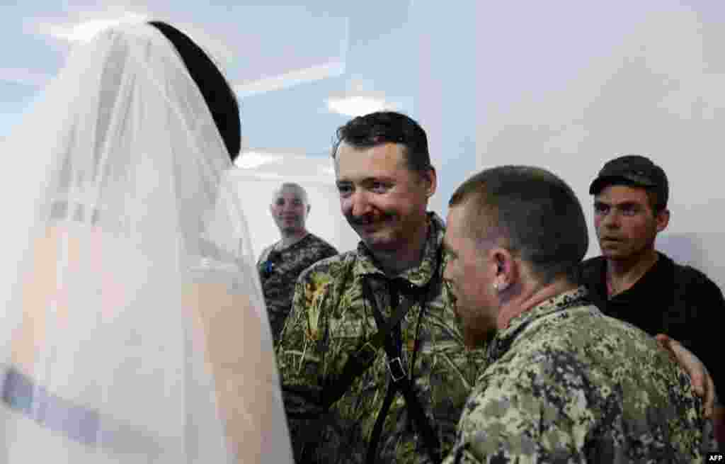 Igor Strelkov (C), commander and self-proclaimed minister of defence of the so called &quot;Donetsk People&#39;s Republic,&quot;&nbsp;congratulates Motorola and Kolenkina during their wedding.&nbsp;