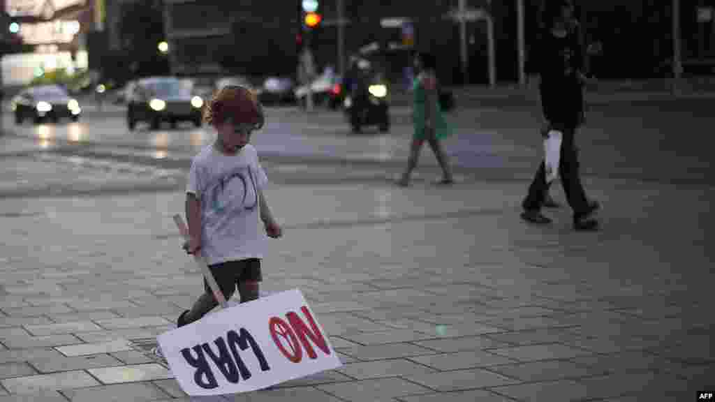 An Israeli child holds a sign during a demonstration on August 23 in the coastal city of Tel Aviv against a possible Israeli military strike on Iran. (AFP/David Buimovitch)