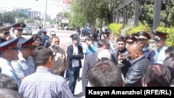 Полицейские разговаривают с людьми, пытающимися пройти на оцепленную площадь Республики. Алматы, 21 мая 2016 года.