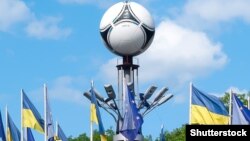 Ukraine – National flags and Adidas tango 12, the official matchball of UEFA EURO 2012 on European Square. Kyiv