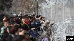 Migrants and refugees wait to cross the Greece-Macedonia border near the village of Idomeni on March 1.