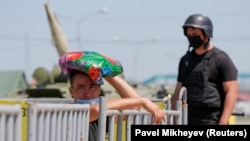 Сотрудник полиции и местный житель на блокпосту около въезда в закрытый на карантин город Алматы. 11 мая 2020 года.
