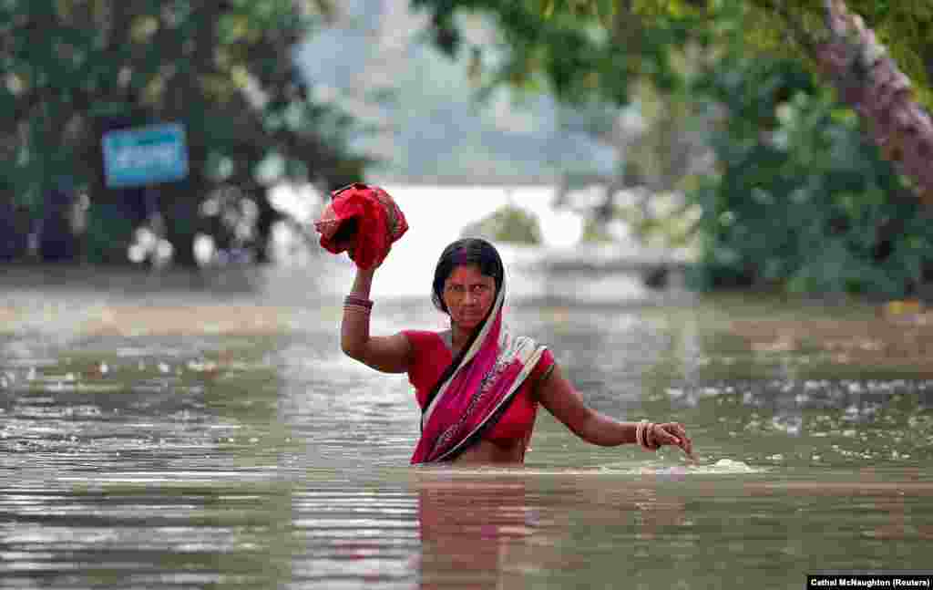 A woman wades through a flooded village in the eastern state of Bihar, India. (Reuters/Cathal McNaughton)