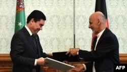 Afghanistan -- Afghan President Ashraf Ghani (R) exchanges documents with Turkmen President Gurbanguly Berdymukhammedov at the Presidential Palace in Kabul, August 27, 2015