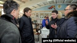 В центре - премьер-министр Сапар Исаков и глава Нацэнергохолдинга Айбек Калиев на ТЭЦ Бишкека. 27 января 2018 года.