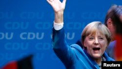 German Chancellor Angela Merkel waves to supporters as she celebrates after the first exit polls at party headquarters in Berlin on September 22.