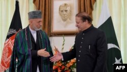 Pakistani Prime Minister Nawaz Sharif (right) greets Afghan President Hamid Karzai in Islamabad on August 26.