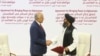 U.S. peace envoy Zalmay Khalilzad, left, and Mullah Abdul Ghani Baradar, the Taliban group's top political leader, shake hands after signing a peace agreement between Taliban and U.S. officials in Doha on February 29.