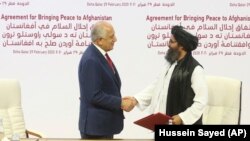 Zalmay Khalilzad (solda) və Molla Abdul Ghani Baradar, arxiv fotosu