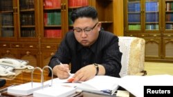 Лидер КНДР Ким Чен Ын подписывает приказ о запуске межконтинентальной ракеты
