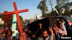 Members of the Pakistani Christian community carry wooden crosses and a casket during a demonstration to condemn the death of a Christian couple (file photo).