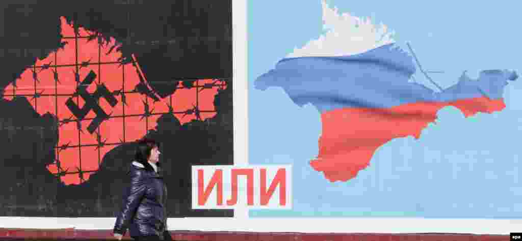 Кабета праходзіць паўз плякат, які прысьвечаны рэфрэрэндуму пра незалежнасьць Крыму, што павінен адбыцца 16 сакавіка