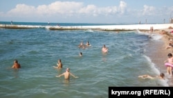 Люди купаются на пляже возле парка Победы