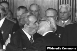 The Kazakh poster is a takeoff of the famous kiss between Soviet leader Leonid Brezhnev (left) and East German leader Erich Honecker.